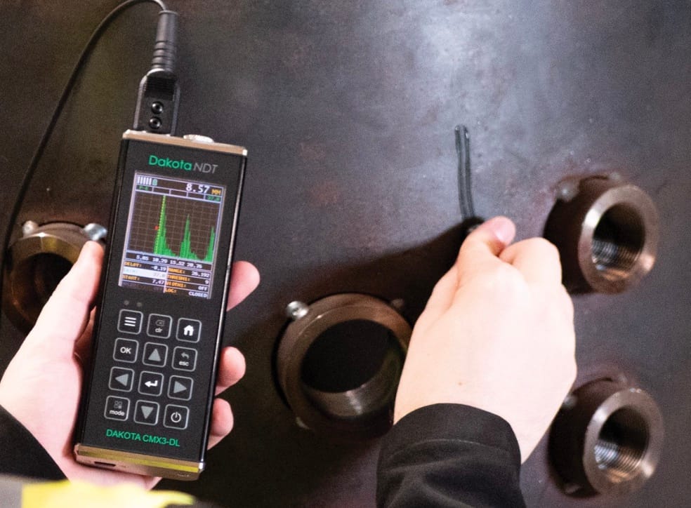 Putcorrosie detecteren wanddiktemeter: Industriële manometer en klep met rode verf en roest
